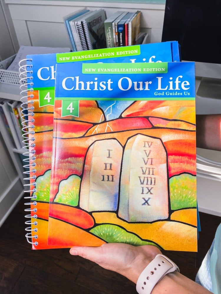 a hand holding christ our life workbooks