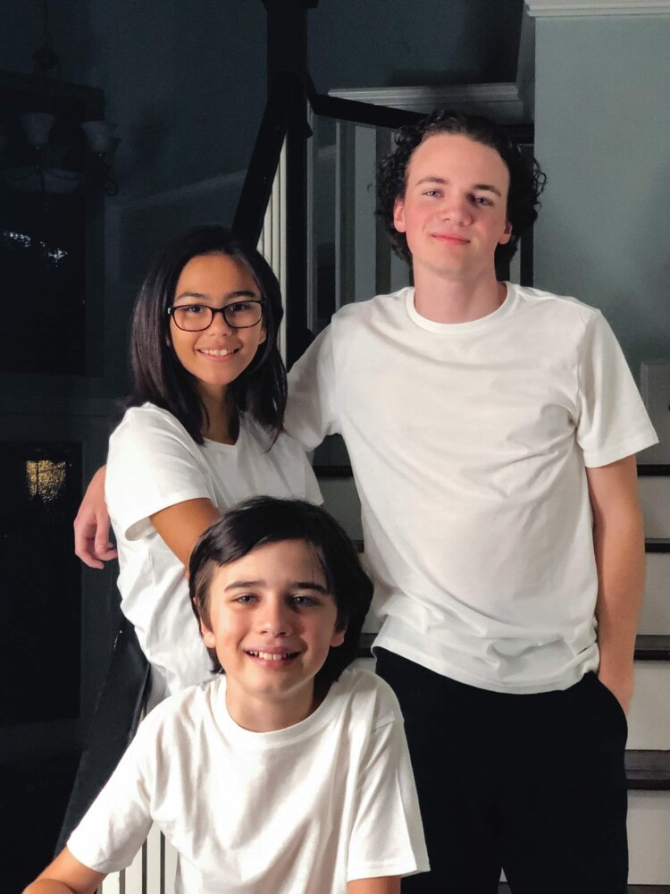 a young boy, teen girl, and teen boy standing on stairs