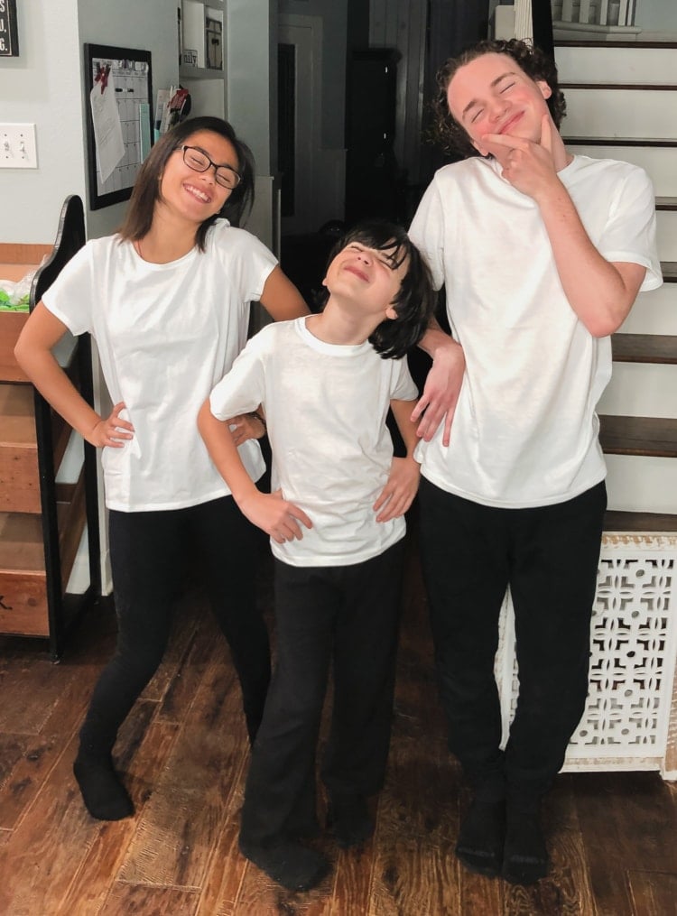 a young girl a young boy and a teenage boy all wearing white t shirts and black pants and making silly faces