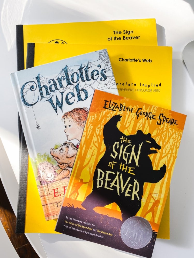 top view of charlotte's web book and the sign of the beaver book on top of two total language plus yellow workbooks