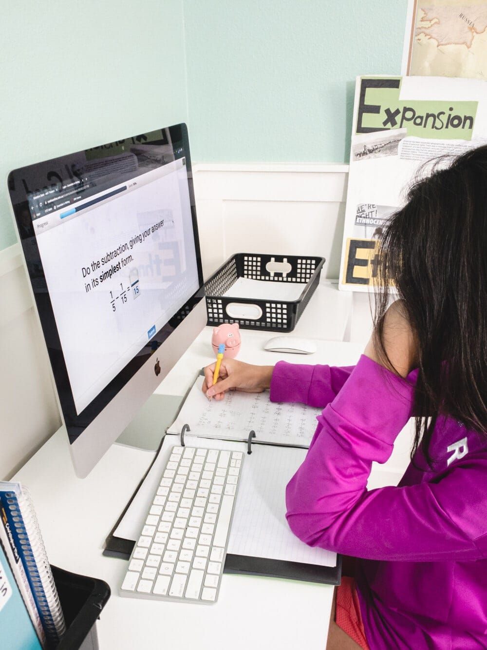 a girl doing ctc math work on a desktop computer at a small desk during homeschool