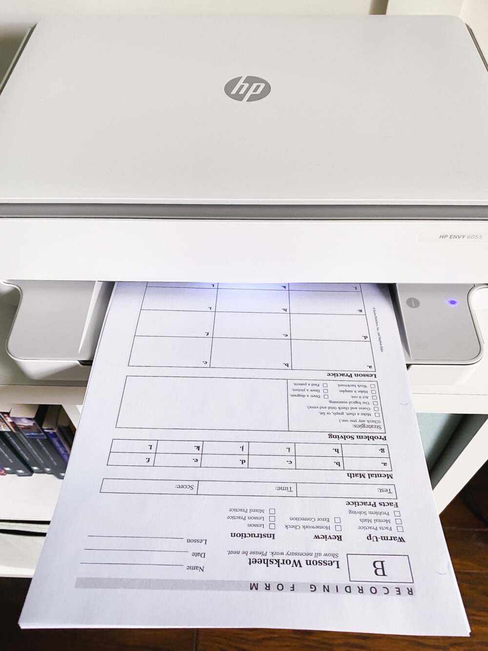 copies of saxon math 5/4 worksheets sitting in the tray of a copier