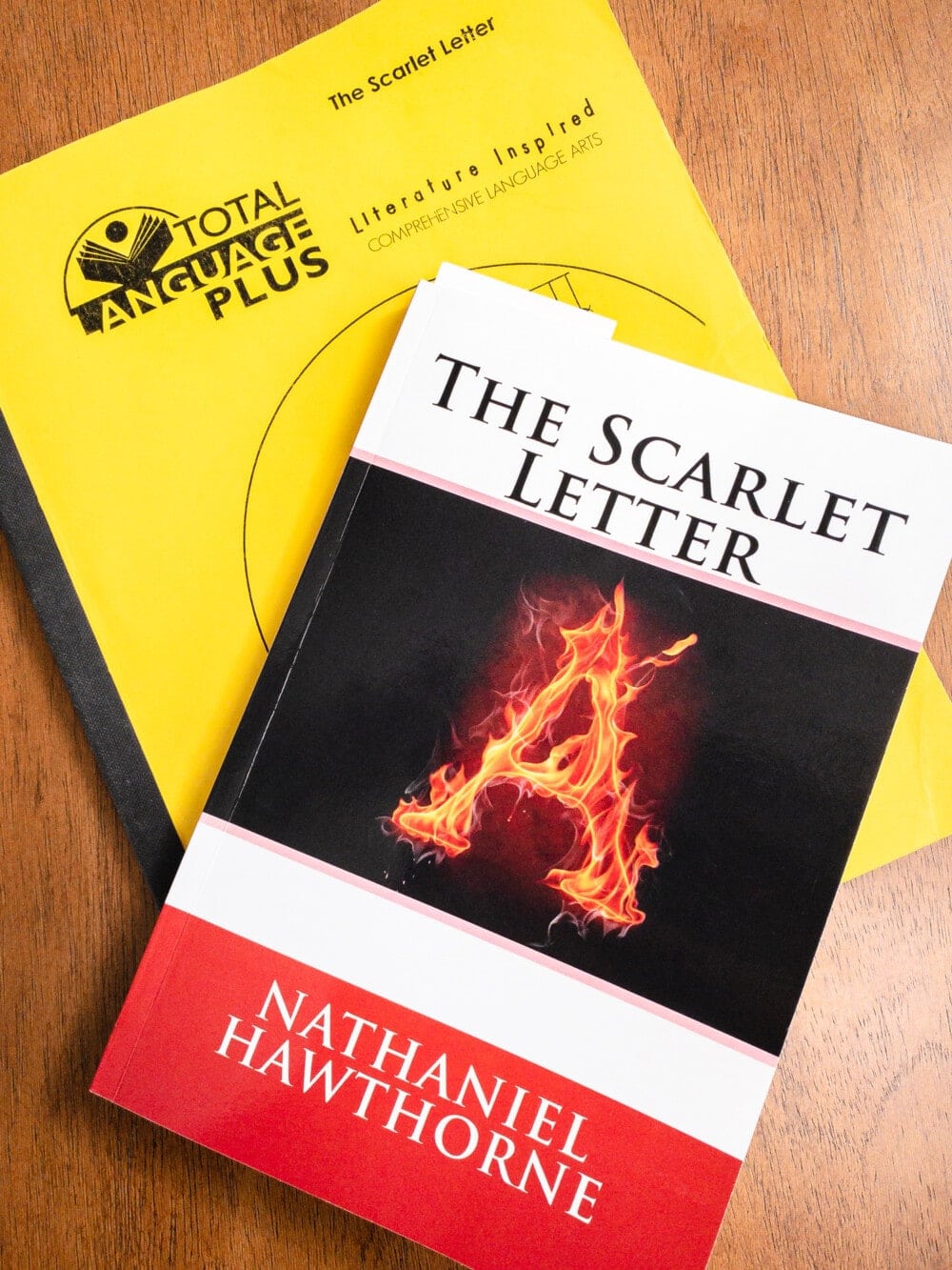 a yellow total language plus workbook and the book the scarlet letter stacked on a table